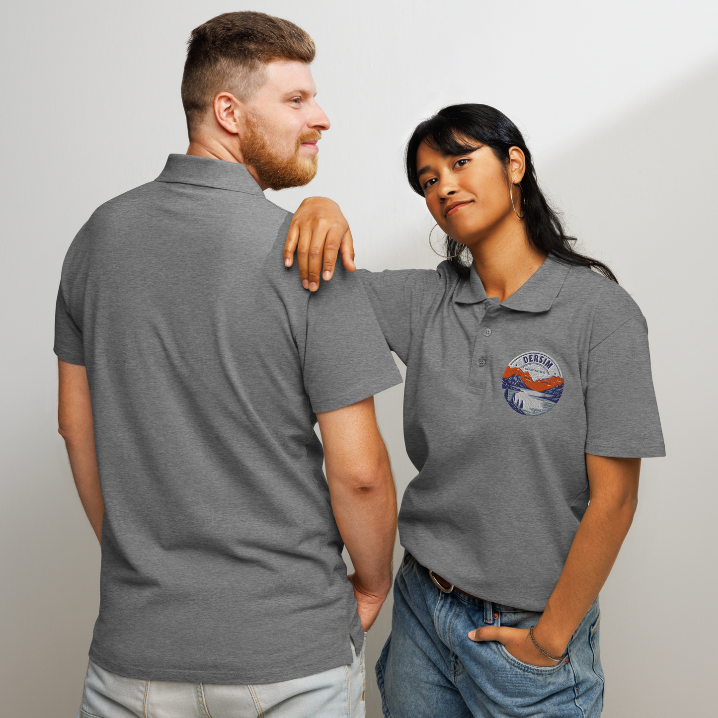 Unisex premium Polo Shirt grau mit rundem Brustemblem