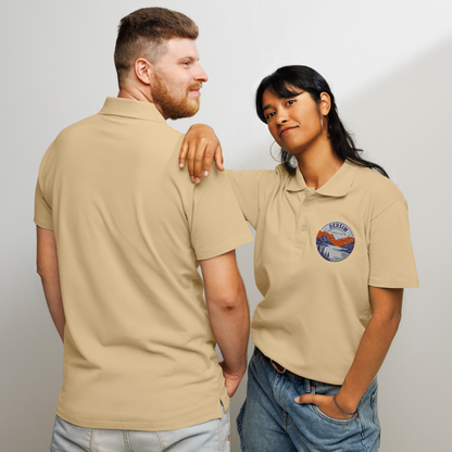 Unisex premium Polo Shirt sandfarben mit rundem Brustemblem